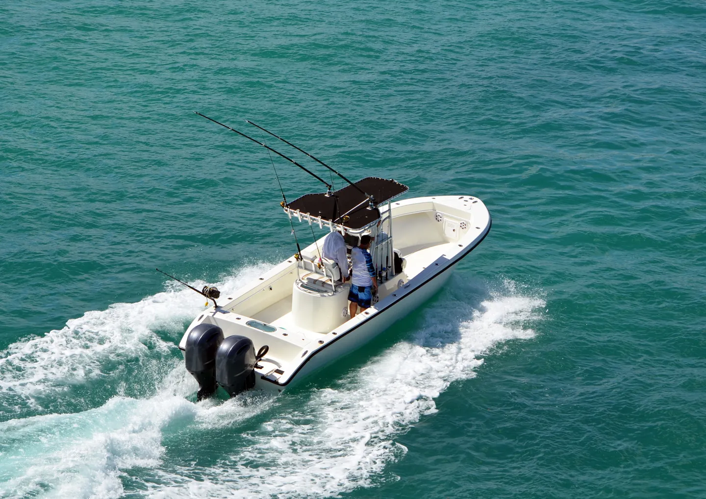 Center-console fishing boat running through open water